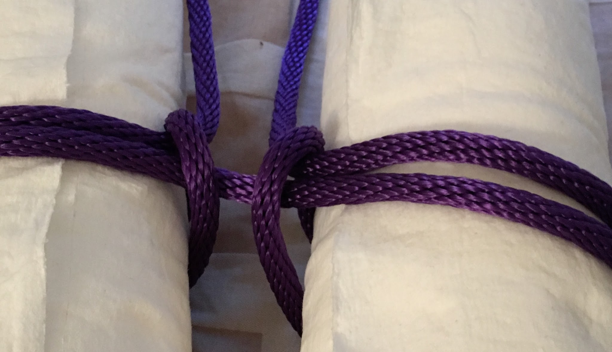 Close-up of rope tied around two paper towel rolls