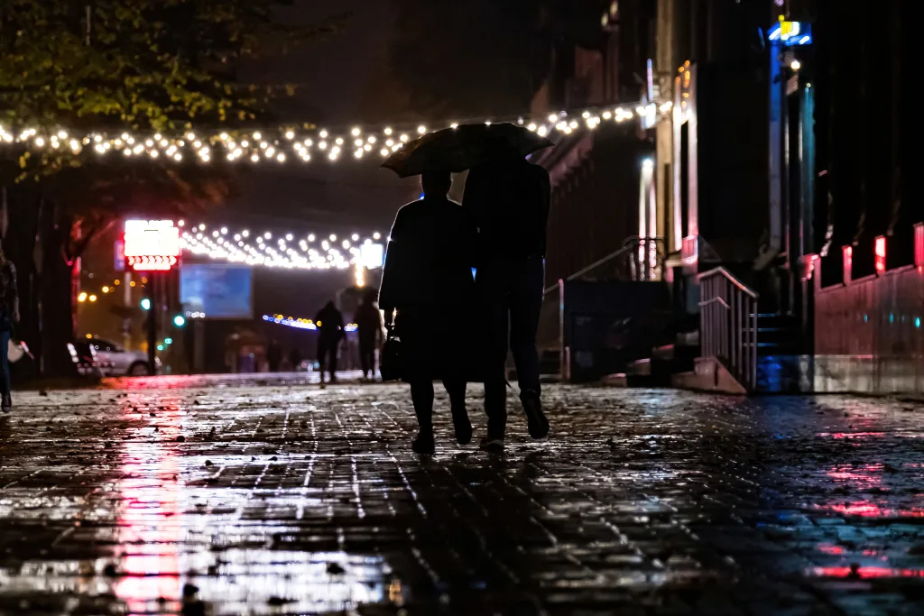 Couple walking at night with umbrella