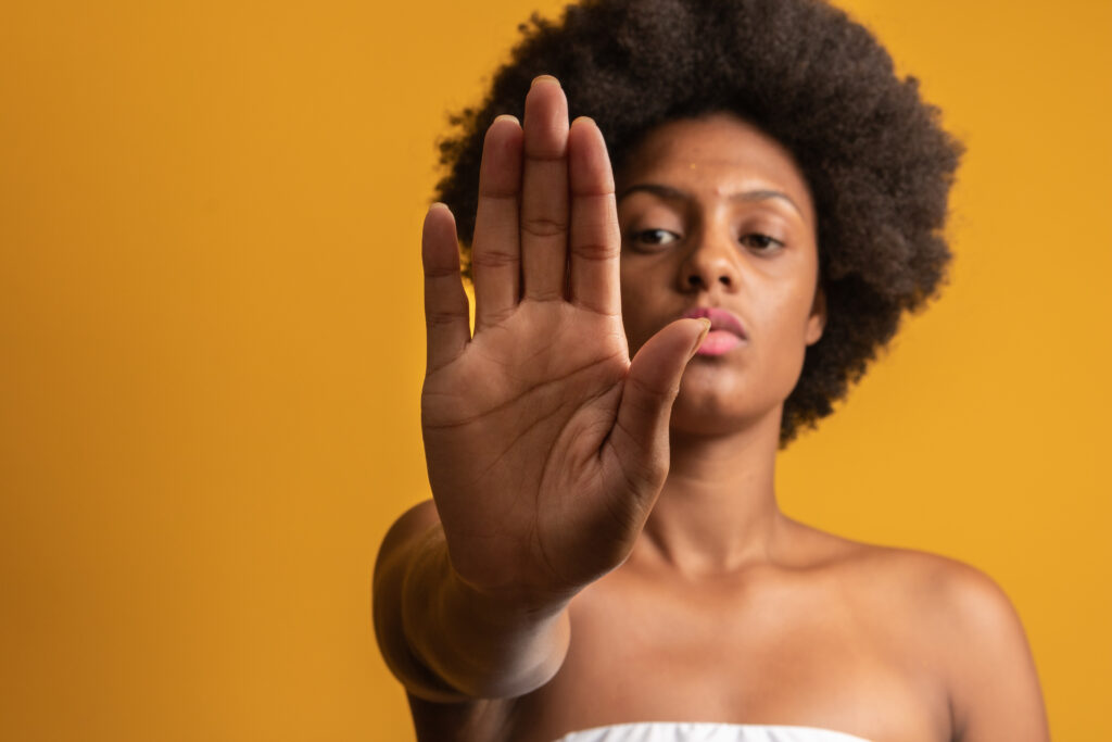 A black woman with hand raised in a "stop" gesture.
