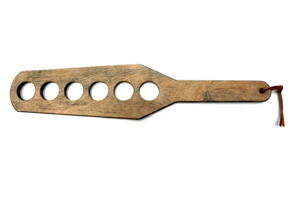 Wooden paddle with holes in it
